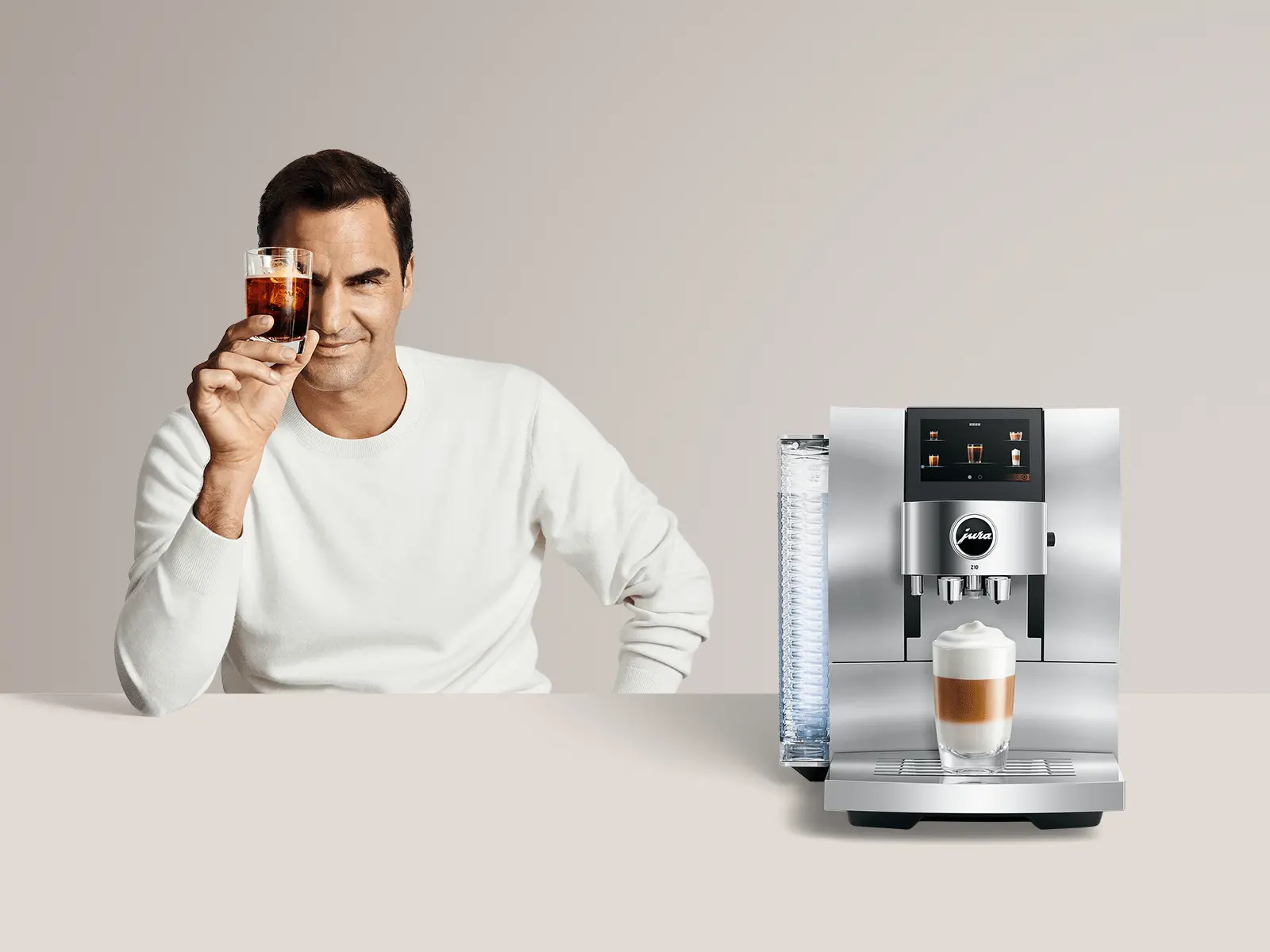 Roger Federer holding a cup of coffee beside the JURA S8 Automatic Coffee Machine