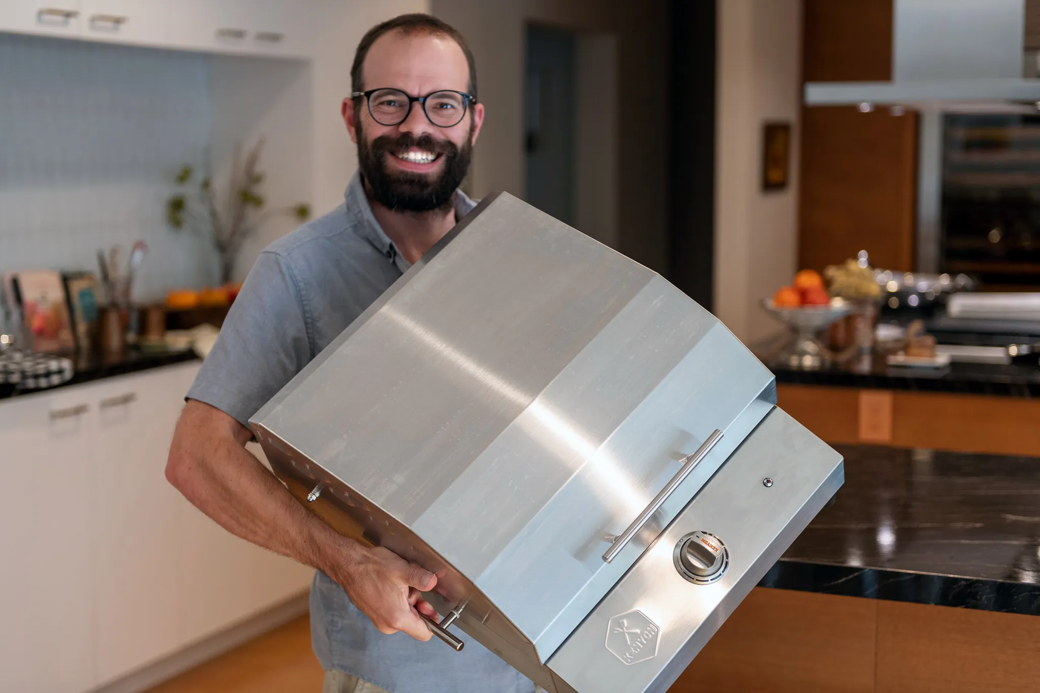 Kenyon G2 Grill dimensions and specifications for portable indoor and outdoor electric grilling. Man holding it up