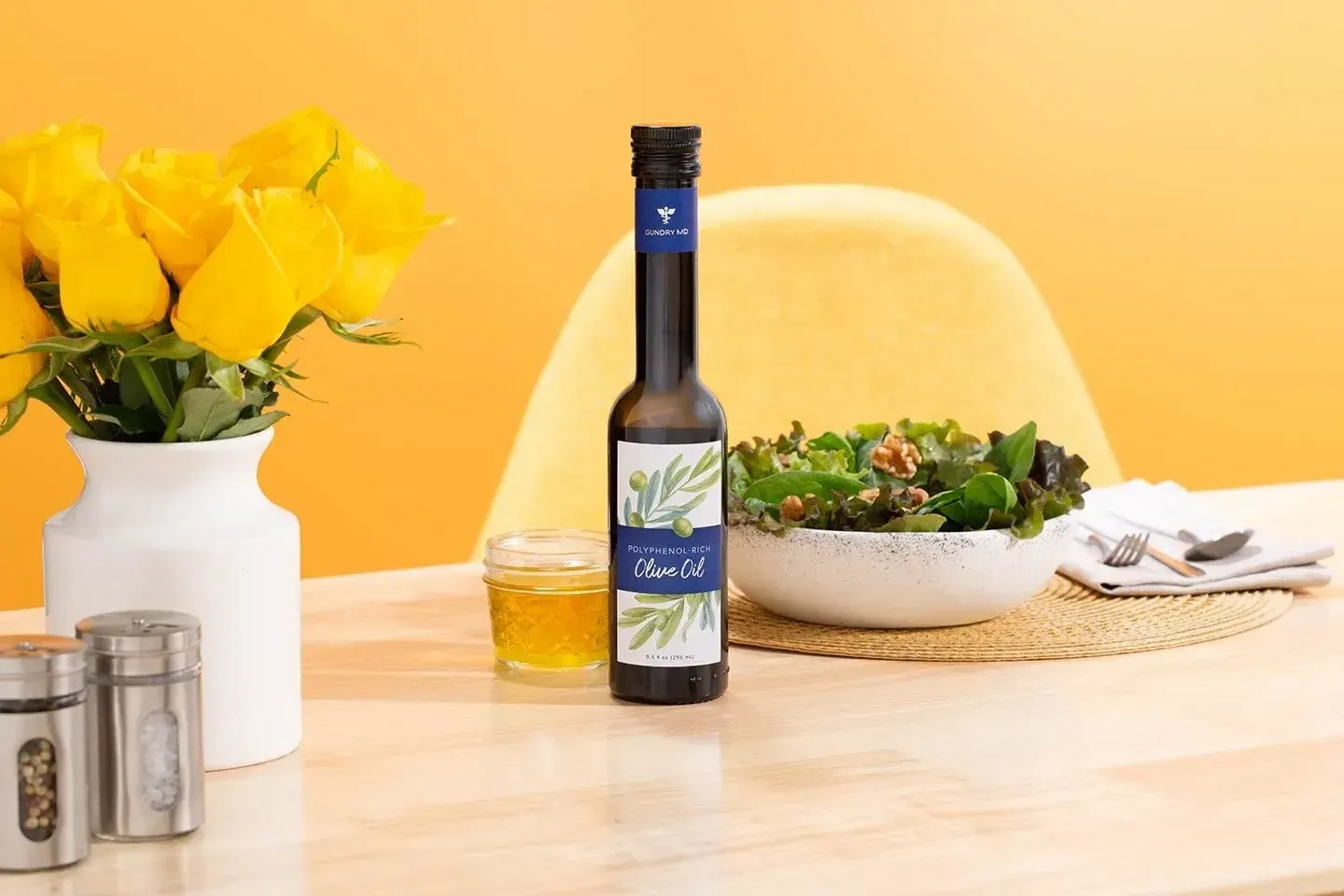 Gundry MD Olive Oil next to salat and flowers