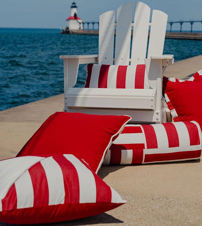 Eastern Accents Pillows for Summer Hosting & Entertaining, here placed on dock with white chair and light tower